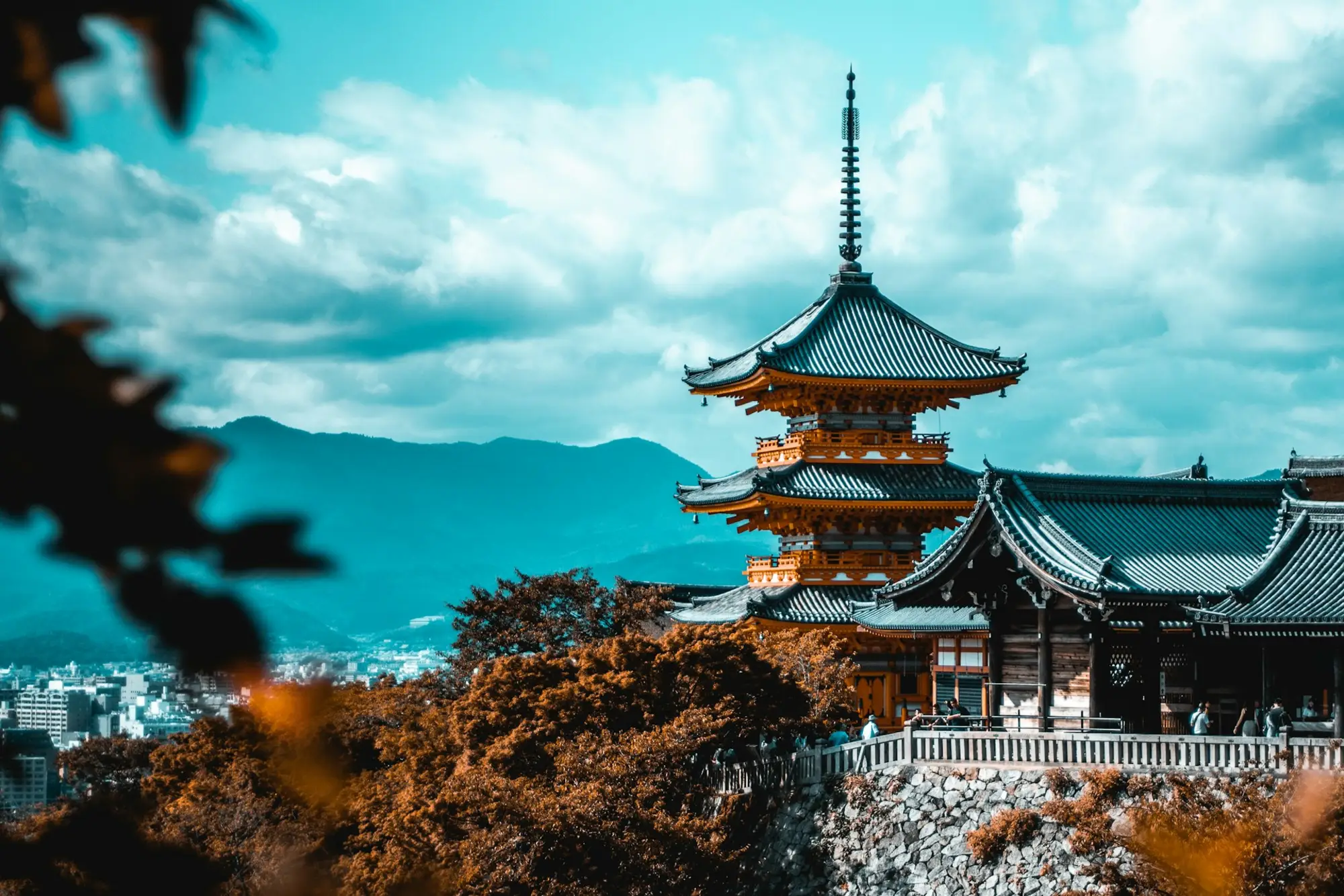 A pagoda above autumn trees on a hillside in Kyoto